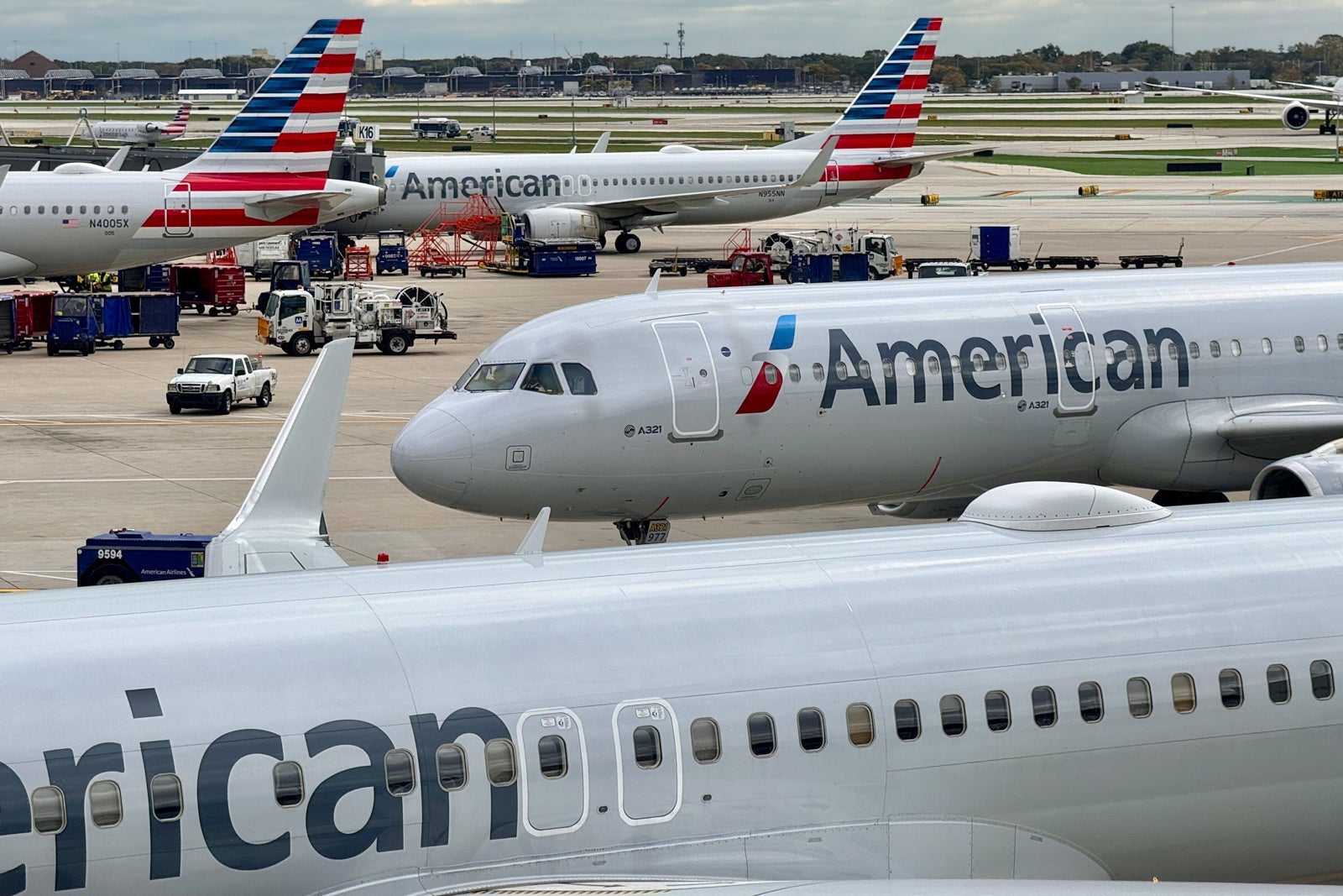 An American Airlines plane taxis to the gate in front of other parked planes