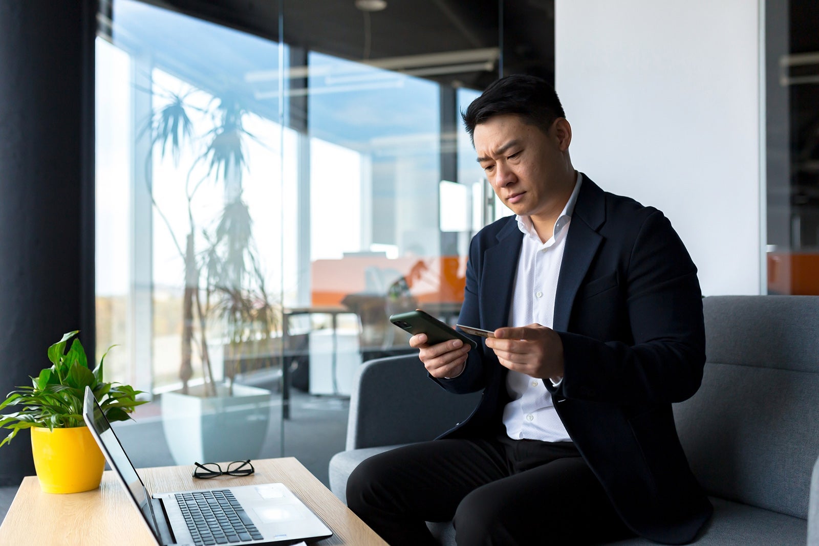 Man looking at his phone in front of a computer