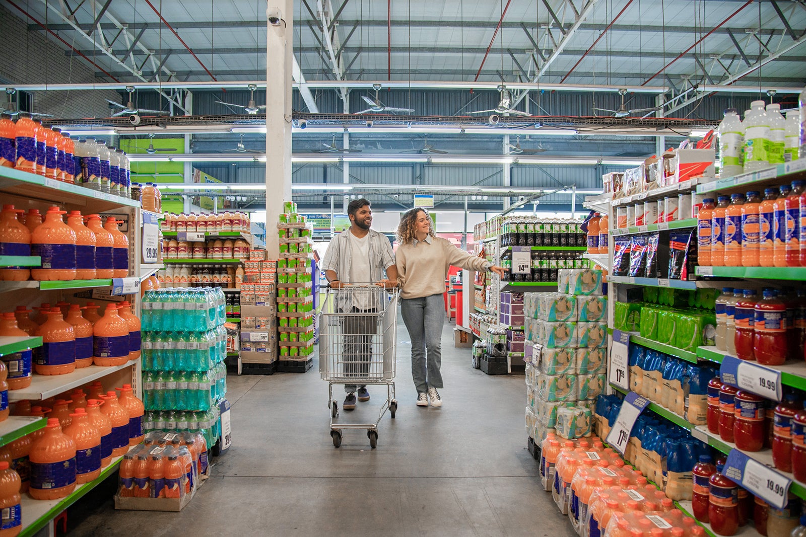 Couple walking down supermarket aisle