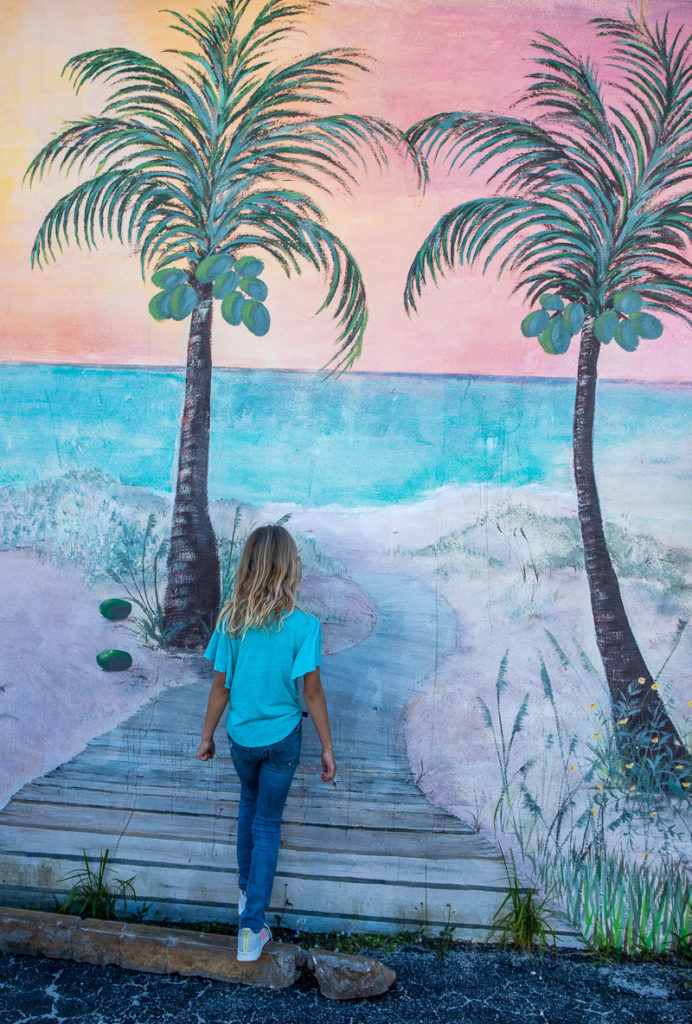 girl standing in front of a wall mural