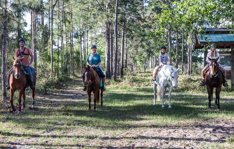 family sitting on horses posing for camera 