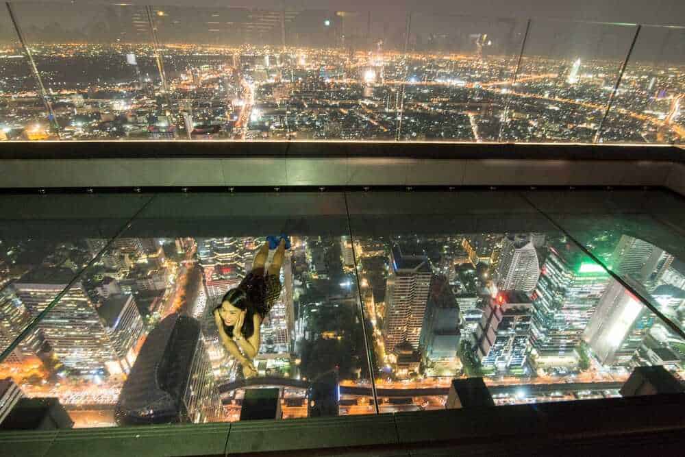 girl lying on glass floor of mahanakhon skywalk
