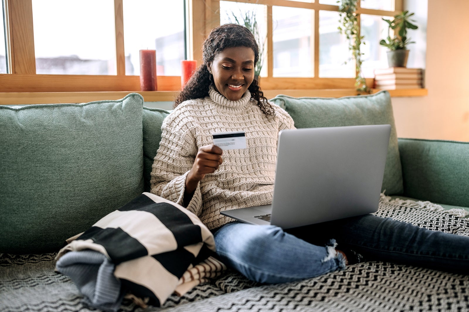 young person on laptop with card