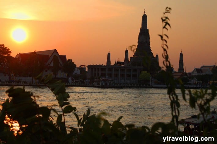 temple silhouette on banks of river at sunset