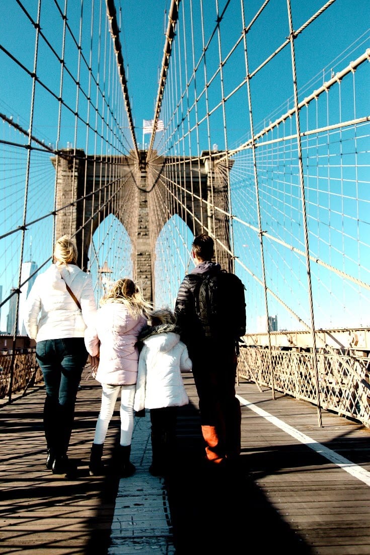 family standing on brooklyn bridge