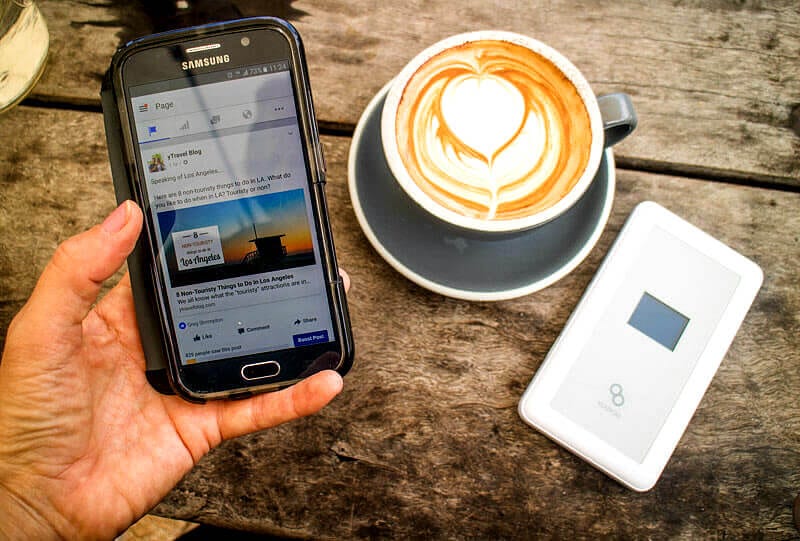 man holding phone next to coffee