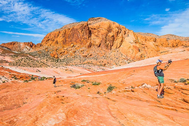 woman taking photo of valley of fire landscape