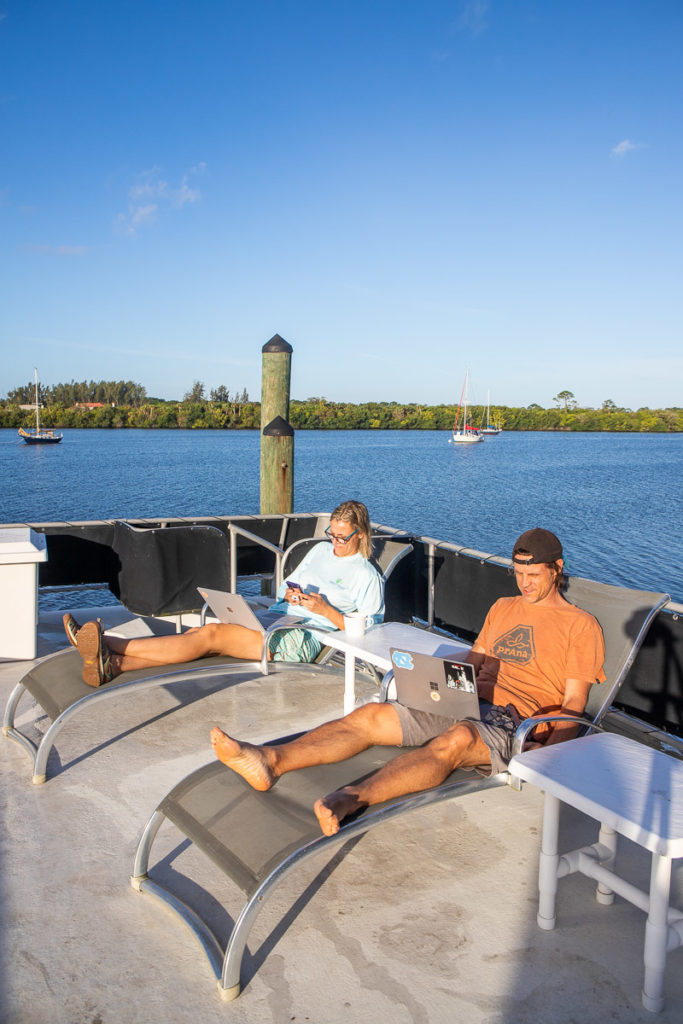 people sitting on a boat working on laptops